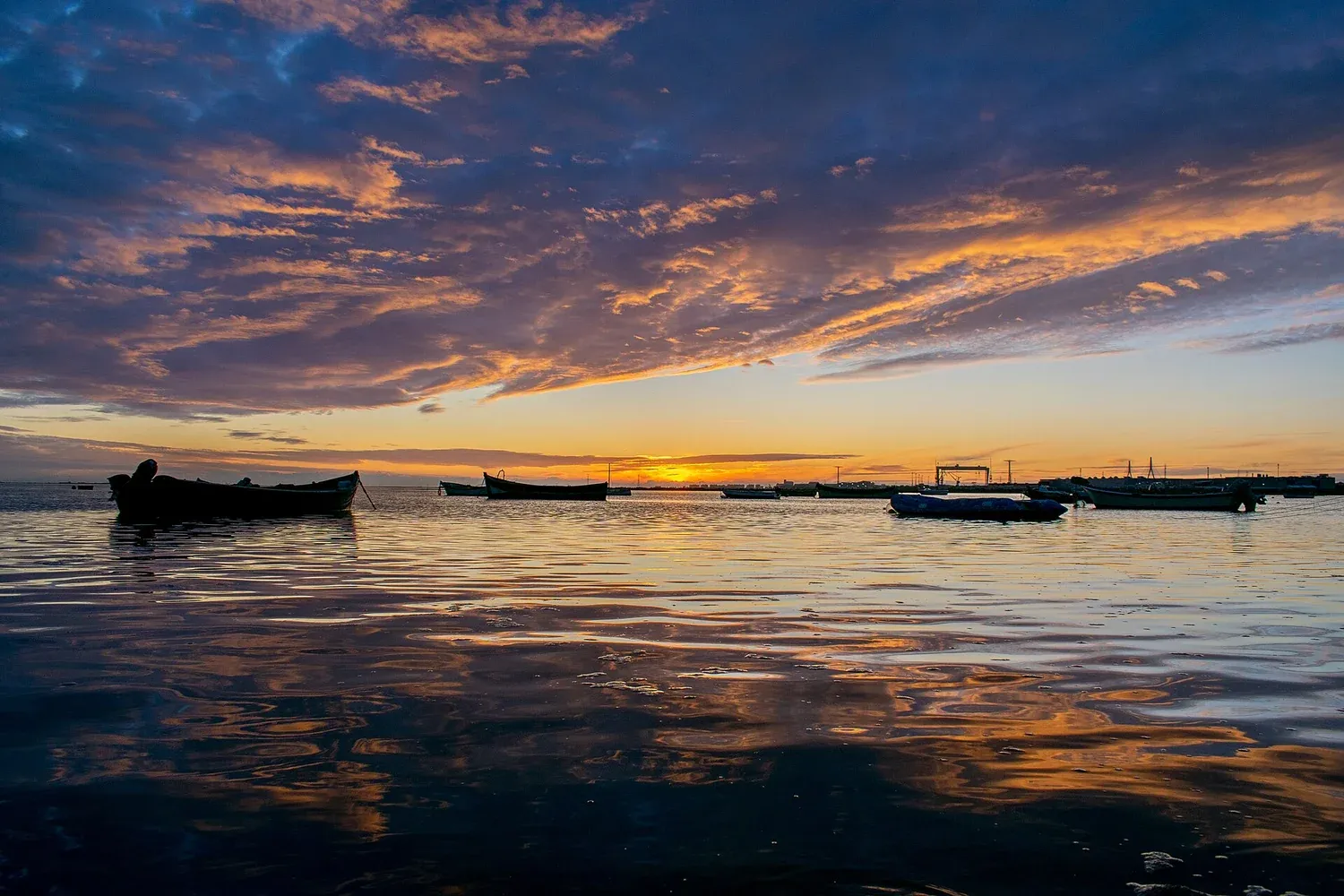 Atardecer sobre la Bahía de Cádiz con barcas de pesca, desde Puerto Real